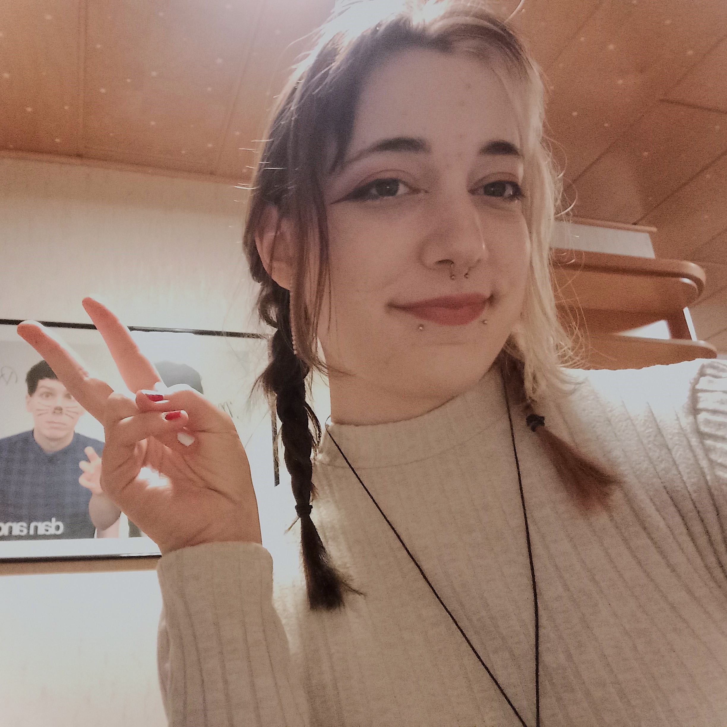 A selfie. I have two short braids and am showing a peace sign.